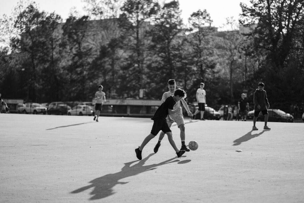 Kids playing football in Italy in black and white