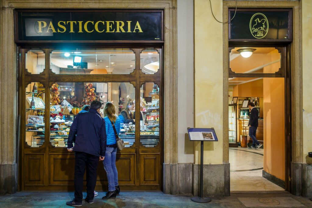 A couple looking inside a pasticceria in Turin