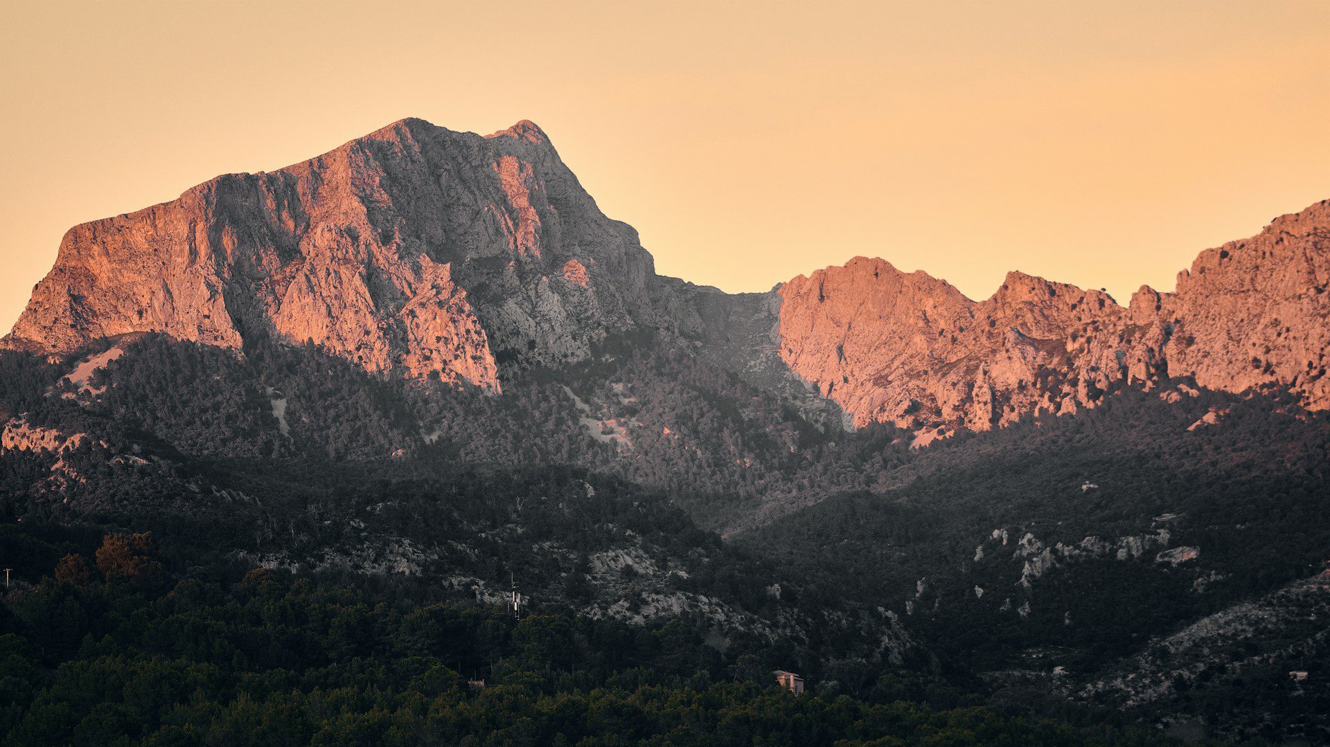 Distant view of rocky hills illuminated at sunset