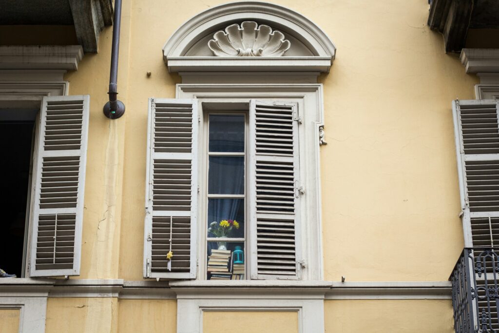Looking up at an apartment window with shutters 