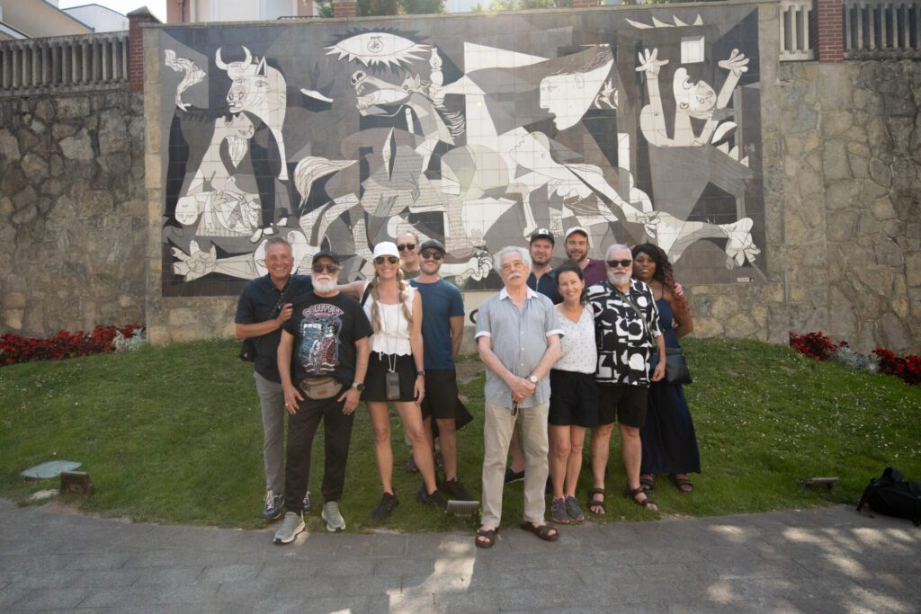 Elders and guests in front of Picasso mural in Guernica