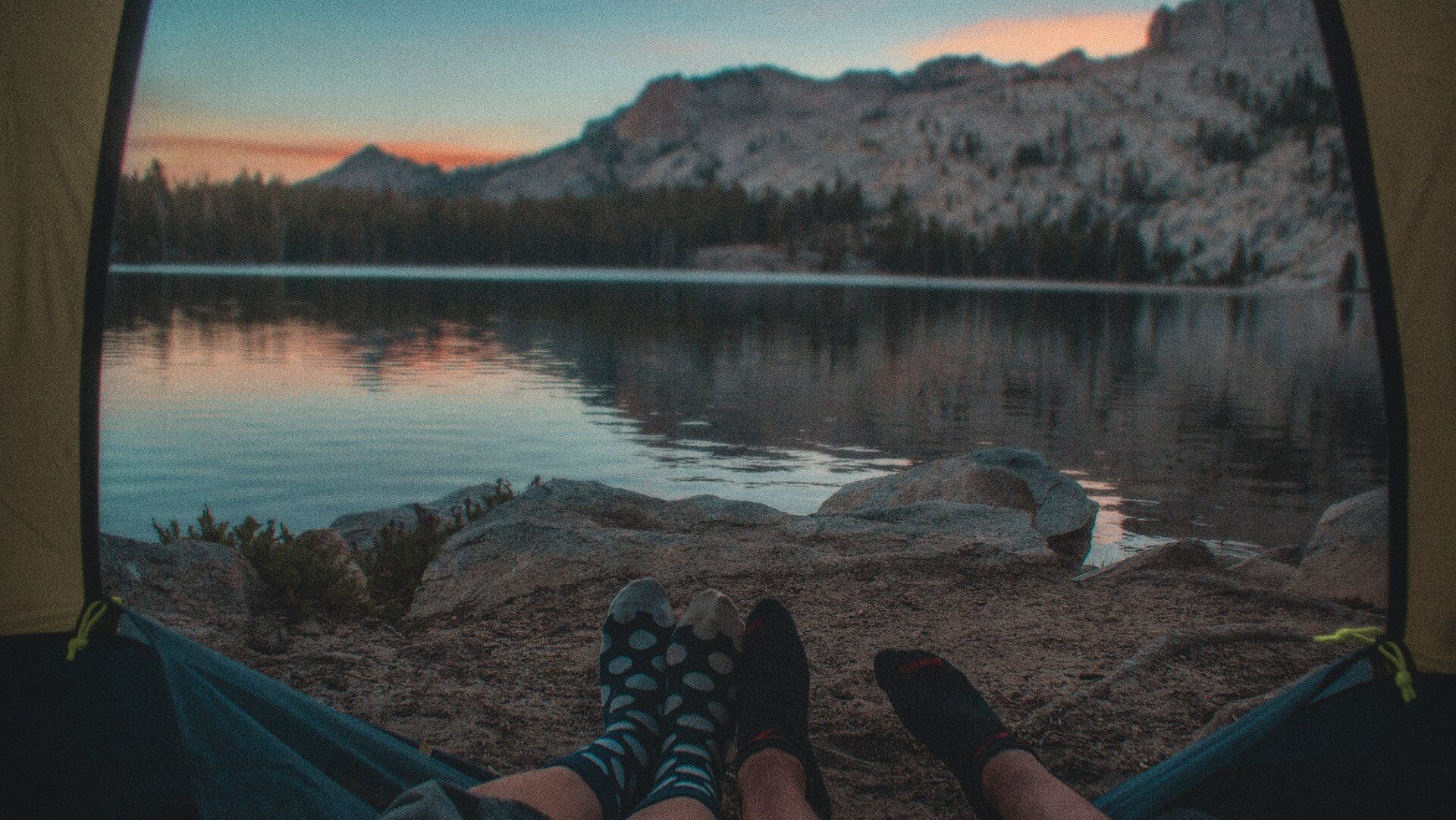 View out the front of a tent looking towards a lake
