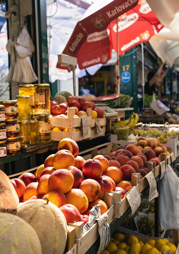 A market stall with peaches, melons and local honey.