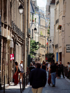 A group of people walking down a street in paris.
