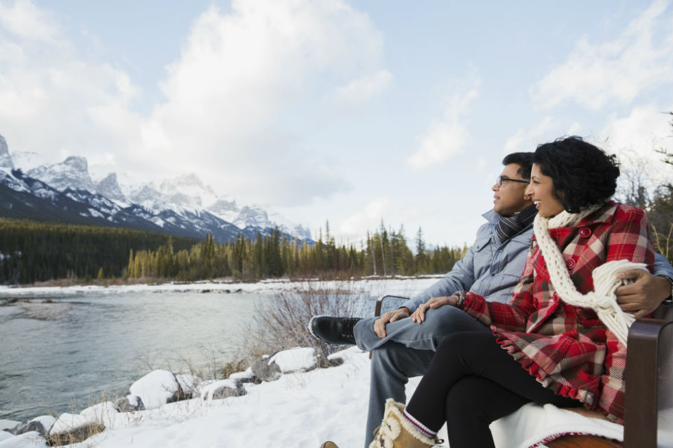 A couple on a bench in overlooking a lake in Switzerland