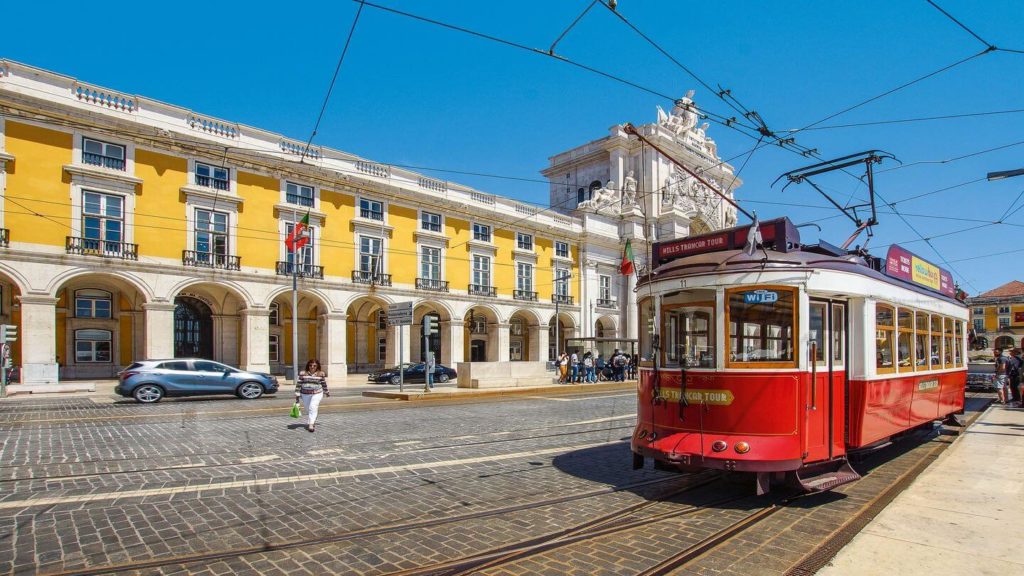 red tram yellow facades lisbon portugal