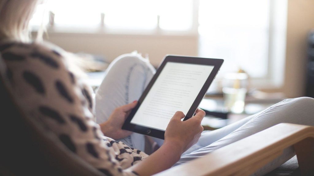woman reading kindle book at home