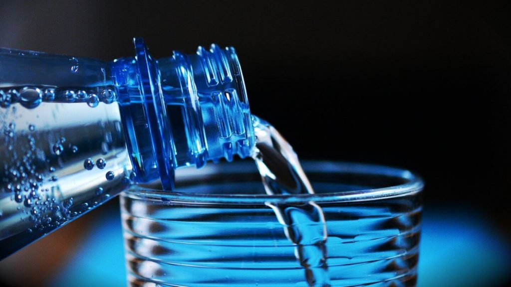 bottle pouring water into glass
