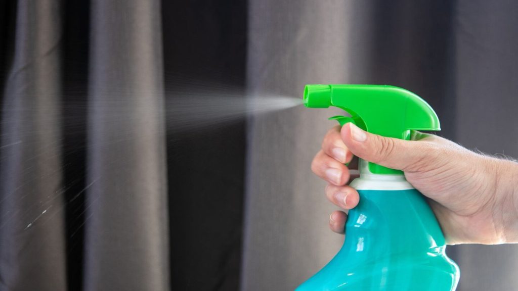 hand holding disinfectant spray hygiene practices