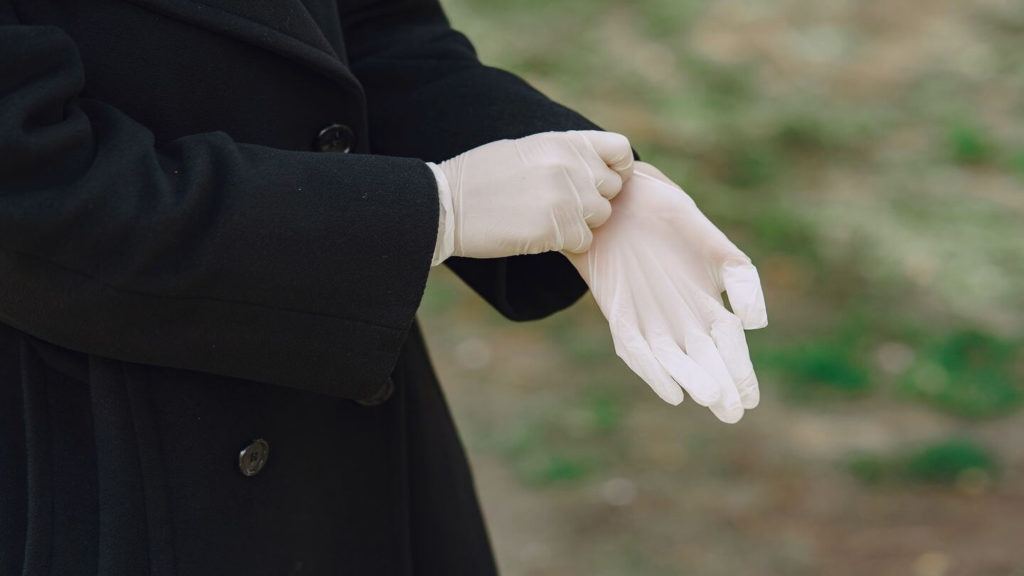 person wearing black coat and disposable gloves