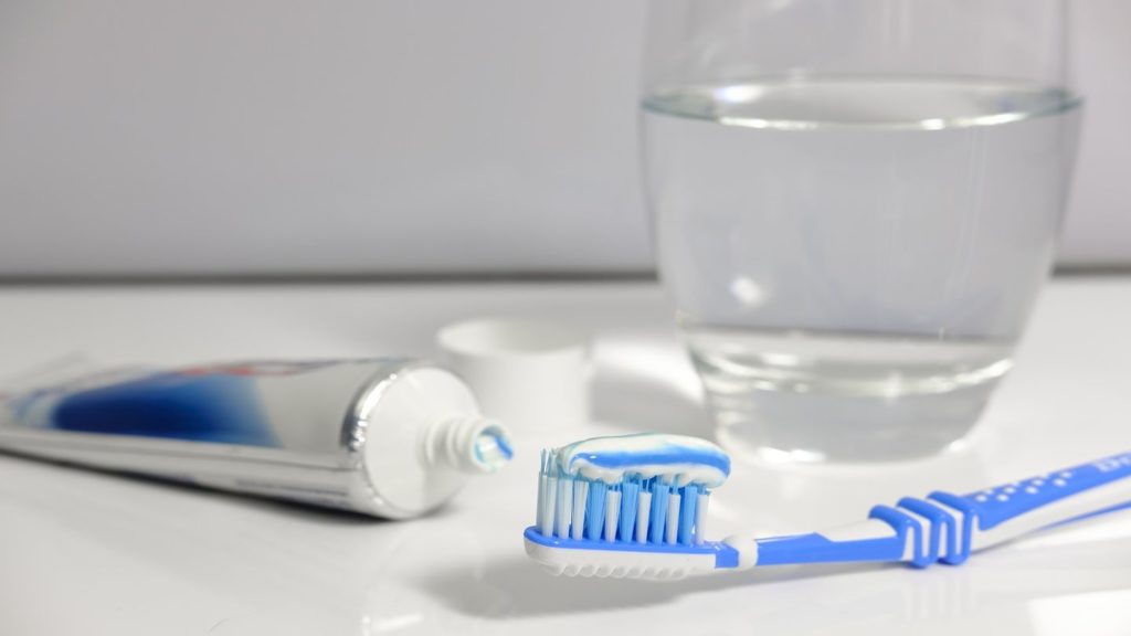 toothpaste toothbrush and glass of water