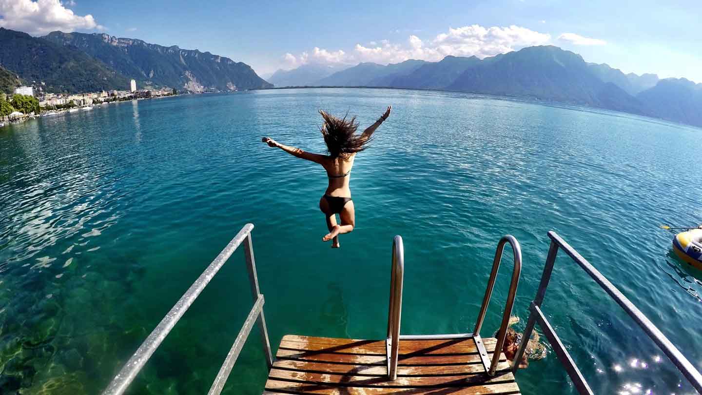 Girl jumping into the water from a pontoon