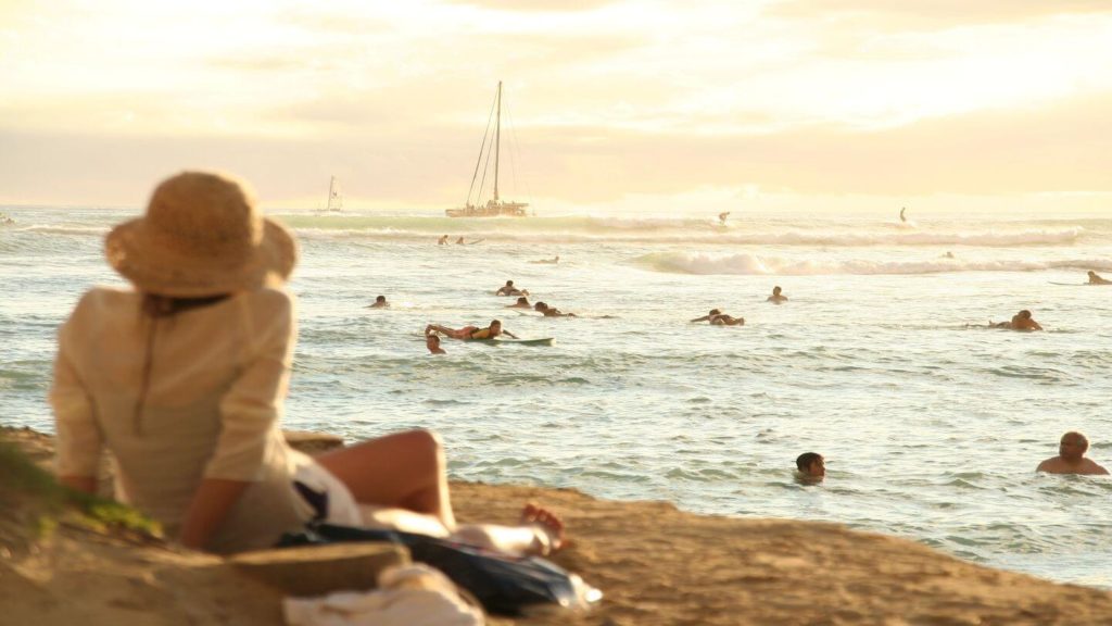 woman sitting on a beach in Hawaii