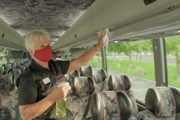 A Trafalgar Wellbeing Director* cleaning a coach