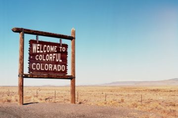 Sign in the sand that says 'welcome to colourful Colorado'