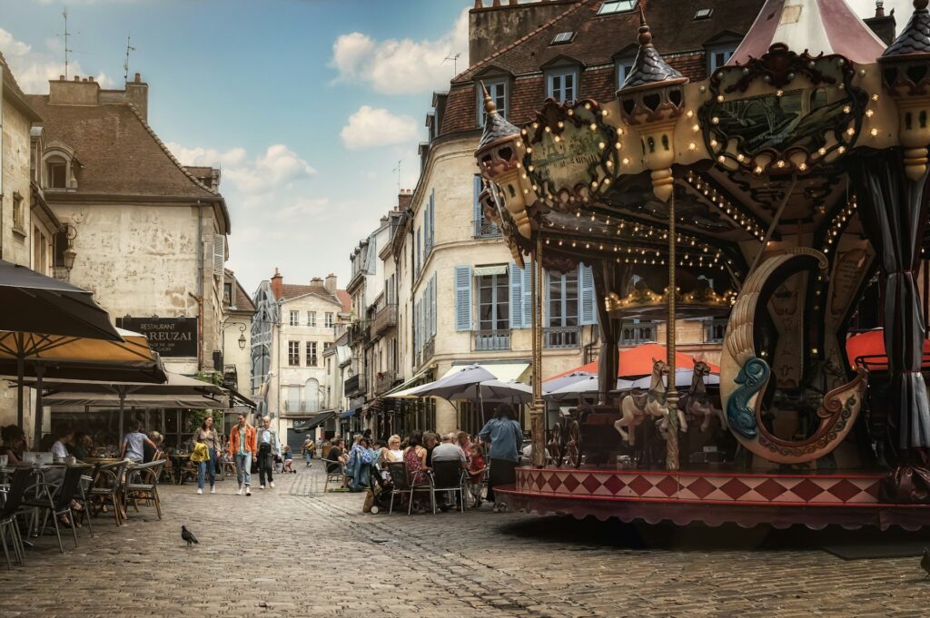 Merry go-round in the medieval centre of Dijon, with cobbled streets and shuttered buildings