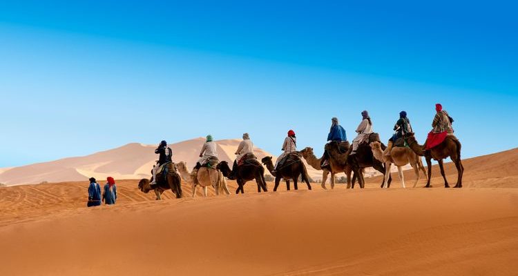 people riding camels in Sahara Desert Morocco