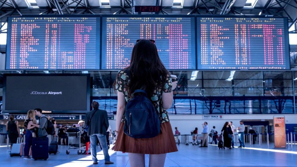 woman at the airport looking at the departure boards