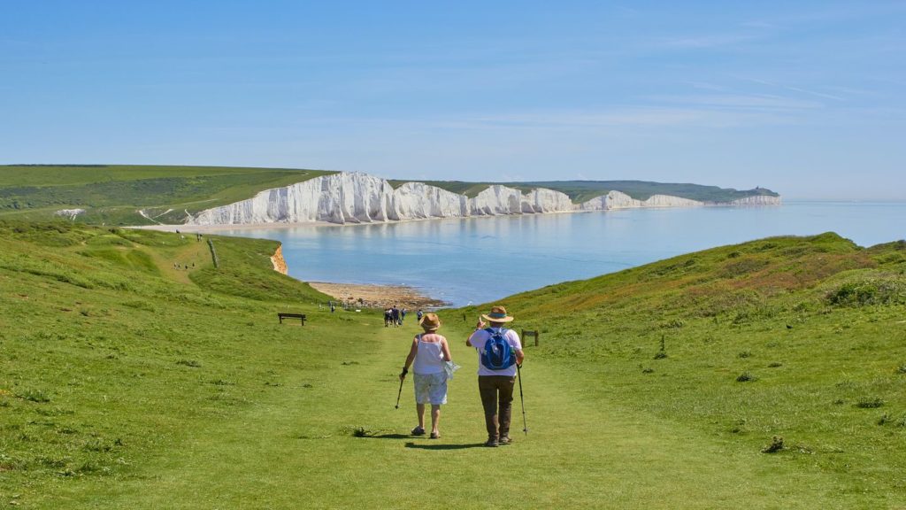 elderly couple walking through green fields near the Cliffs of Dover