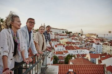 four people standing on a balcony overlooking Lisbon on a Trafalgar tour what travel teaches