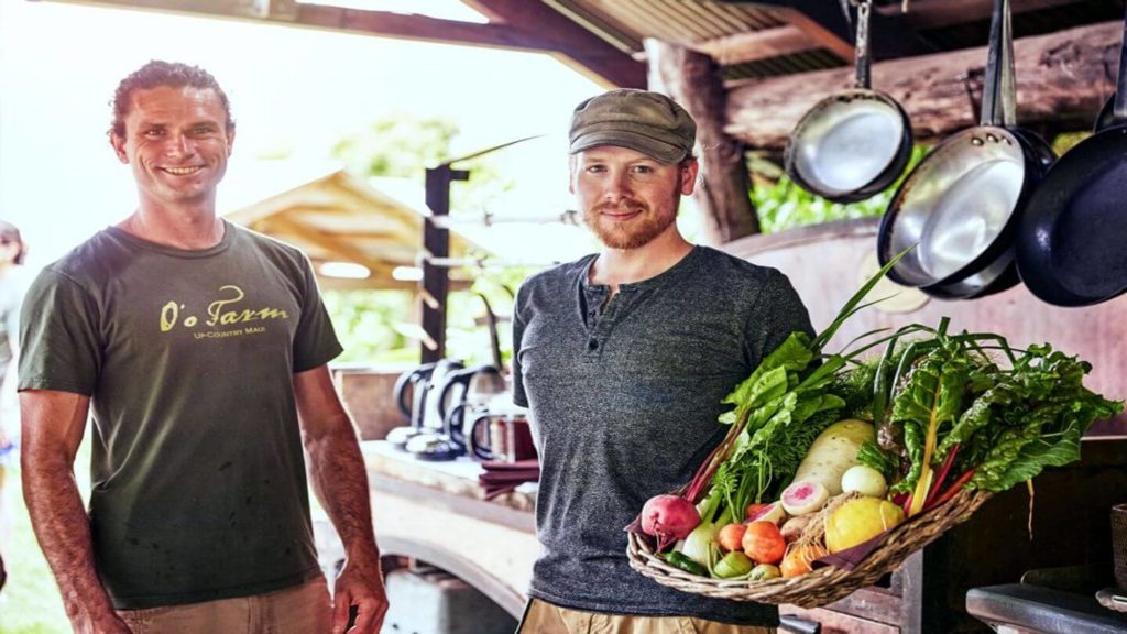 two men holding basket of fresh vegetables Trafalgar Make Travel Matter experience