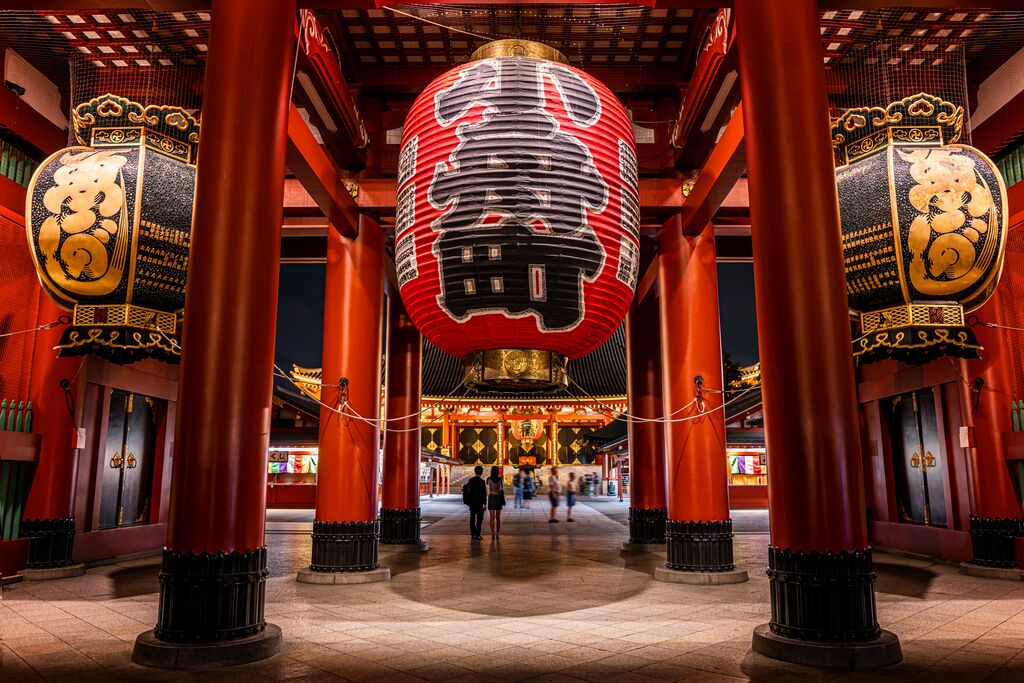 Senso-ji temple in Tokyo. A huge lantern takes up the frame, with large red pillars supporting the temple cascading into the background.