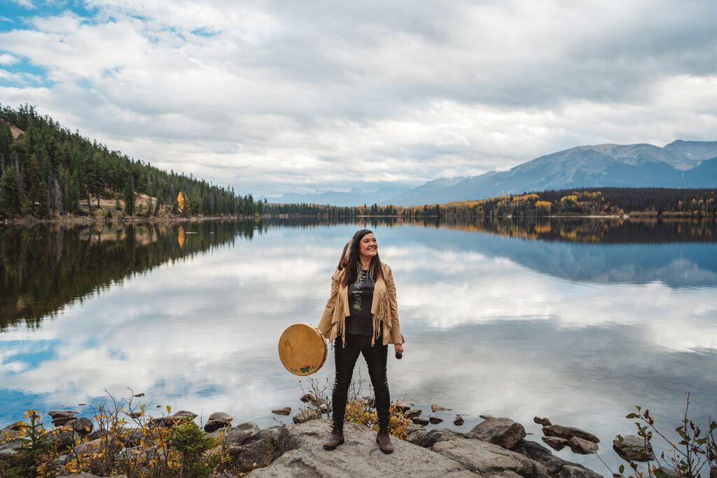 Local host Matricia Brown of Warrior Women standing in front of a lake in Alberta