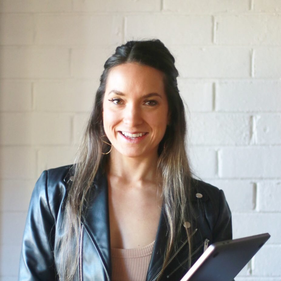 Portrait photo of Kachina standing against a white brick wall