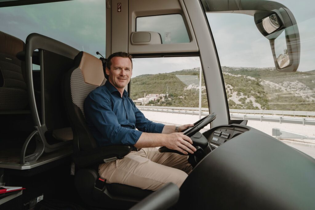 A Trafalgar driver sitting in the driver's seat of one of our coaches. Feel free to tip at the end of your tour!