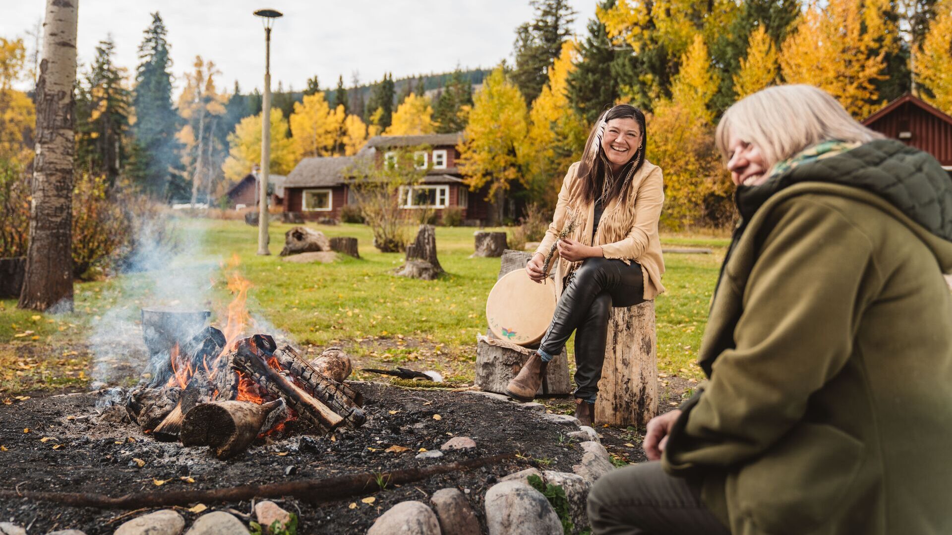 Two people round a campfire on a Be My Guest experience