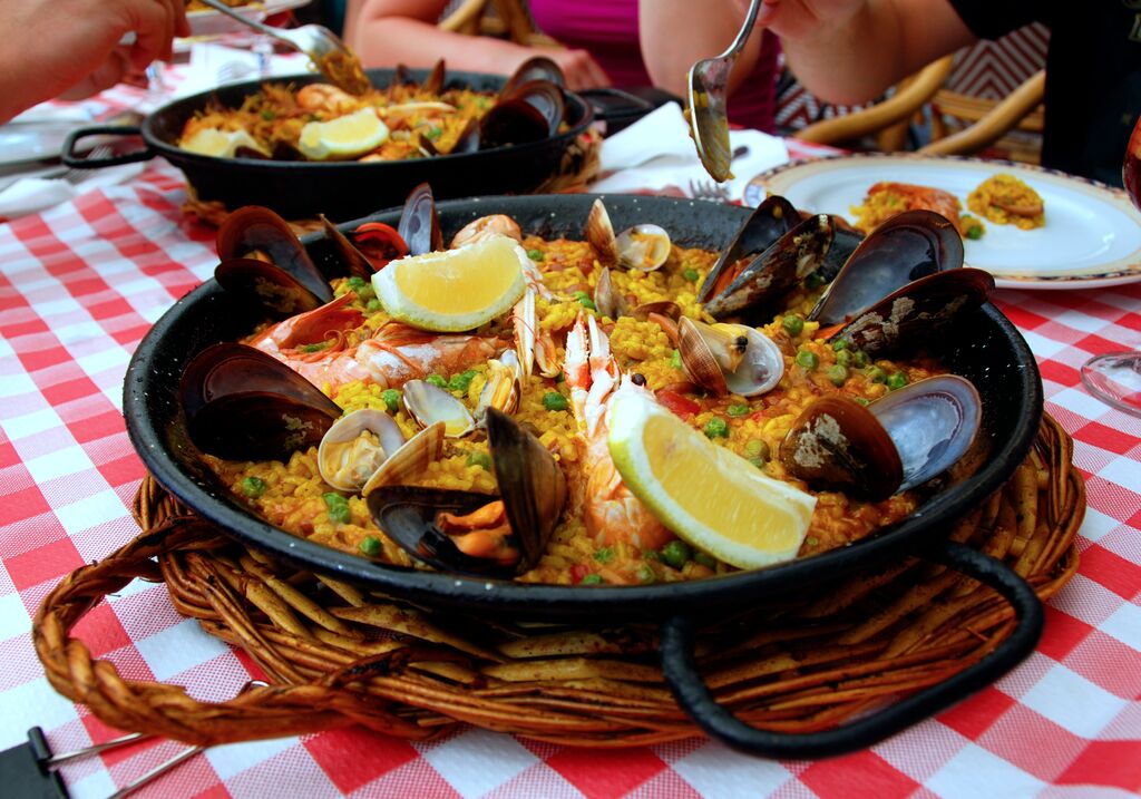 black pan of paella on a checkered tableclot