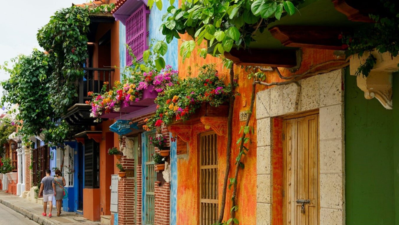 Colorful houses on a street in San Juan, Colombia stand out against the backdrop of the bustling city.
