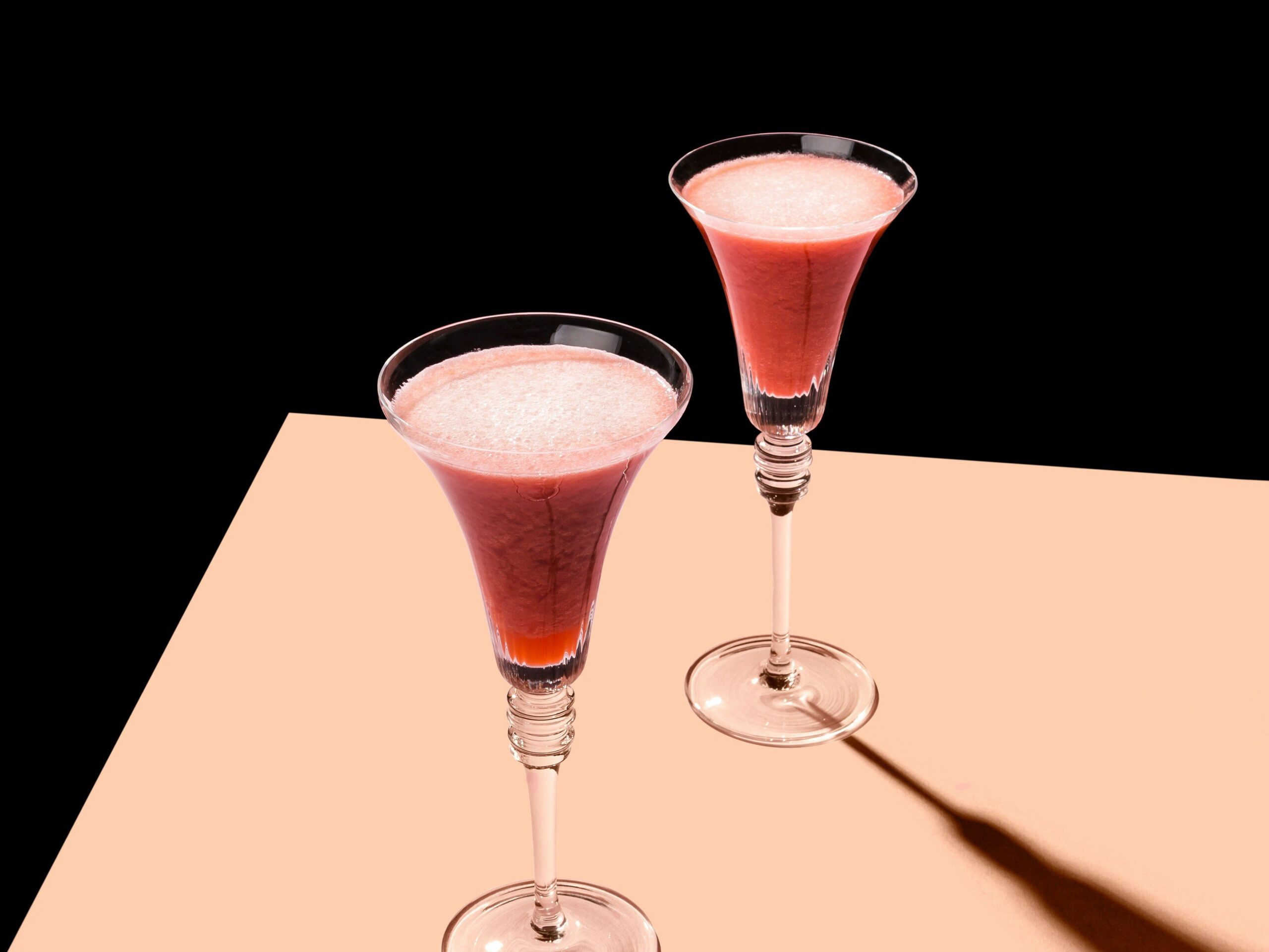 A fizzy red beverage served in a wide-mouthed flute