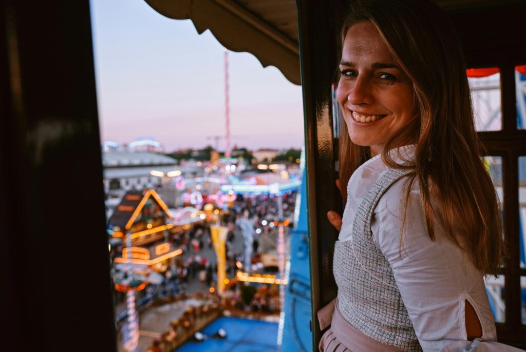 A German lady in a traditional dirndl on the ferris wheel at Oktoberfest in Munich, Germany