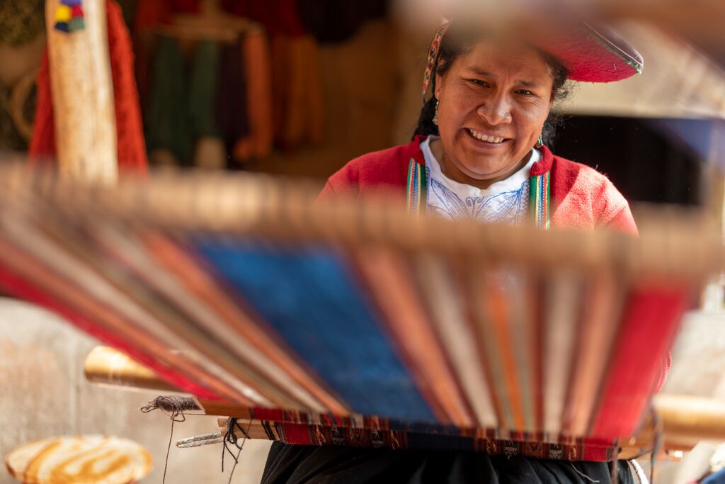 Quechua weaver in Peru weaving on a traditional loom