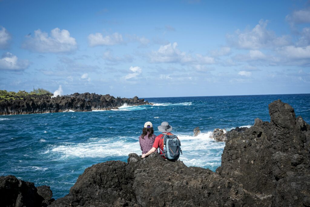 Couple sitting on rocks looking out to sea