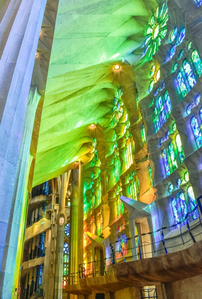 Light filtering through the colorful stained glass windows of the Sagrada Familia